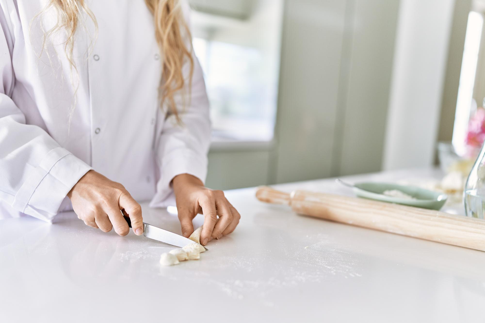 Student kneading dough at a bench